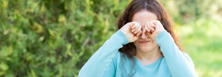 A woman rubbing at her dry, itchy eyes
